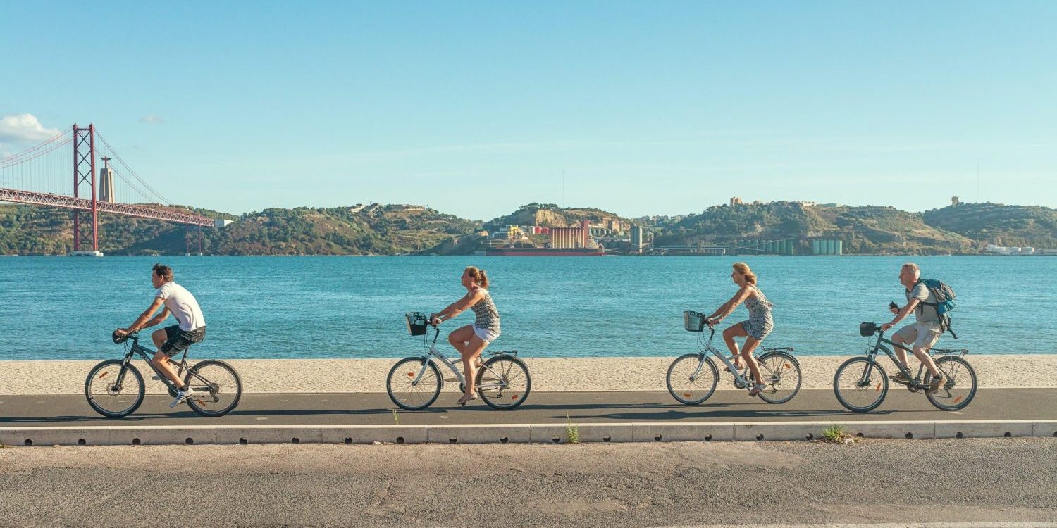 helio-dilolwa-3Yi7garGIHI-unsplash People cycling along a sea front