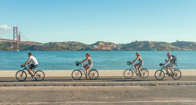 helio-dilolwa-3Yi7garGIHI-unsplash People cycling along a sea front