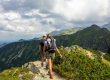A couple hike over a mountain ridge
