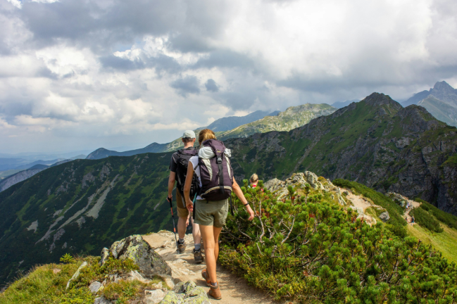 A couple hike over a mountain ridge