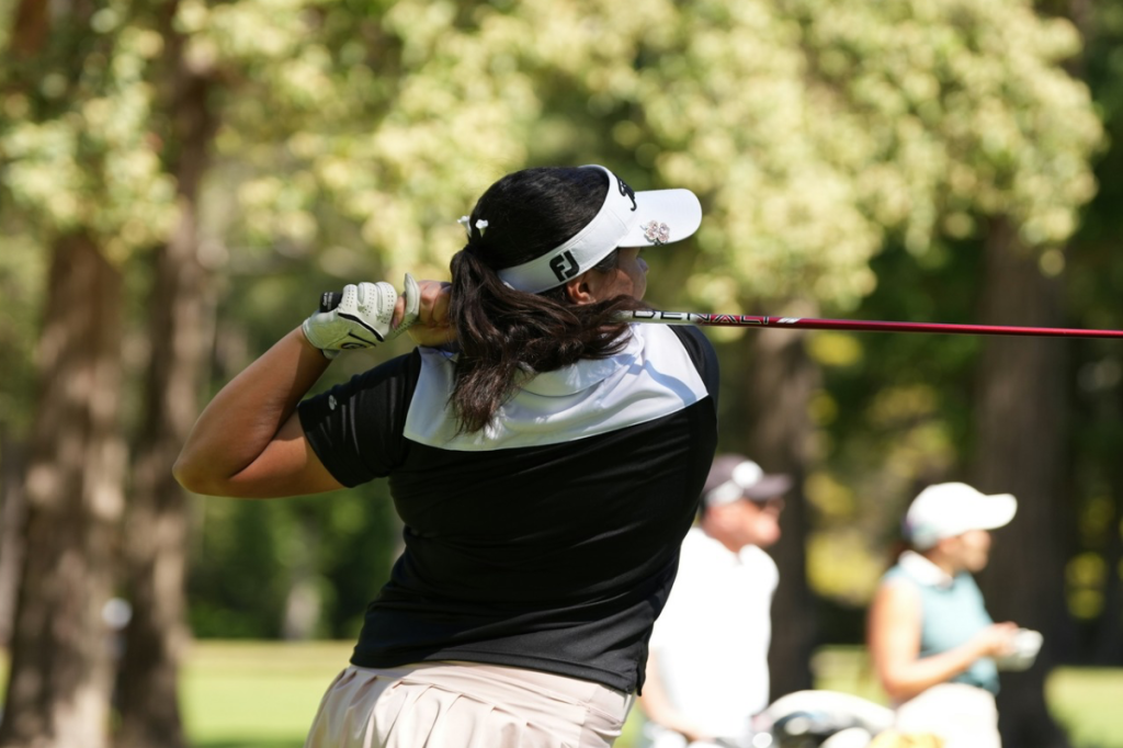 Woman wearing a visor hitting a tee shot